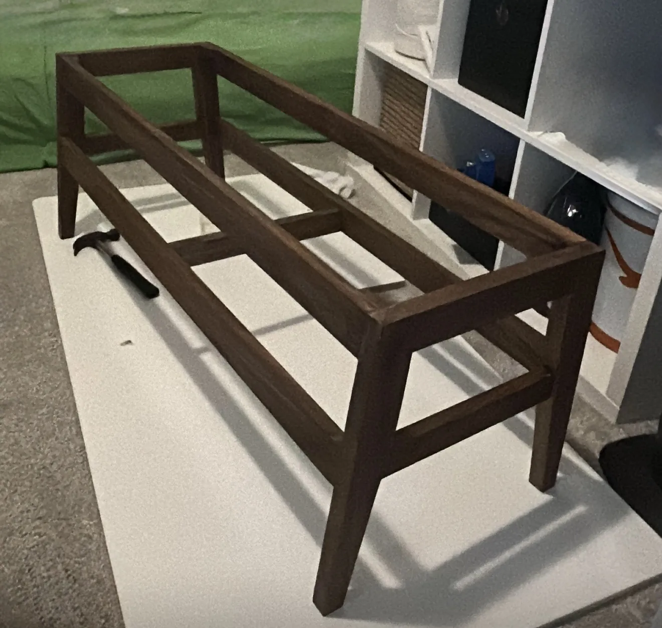 The completed bench frame with no seat on it, finished dark walnut, showing the two long top rails, the lower side stretchers and the cross tie between them