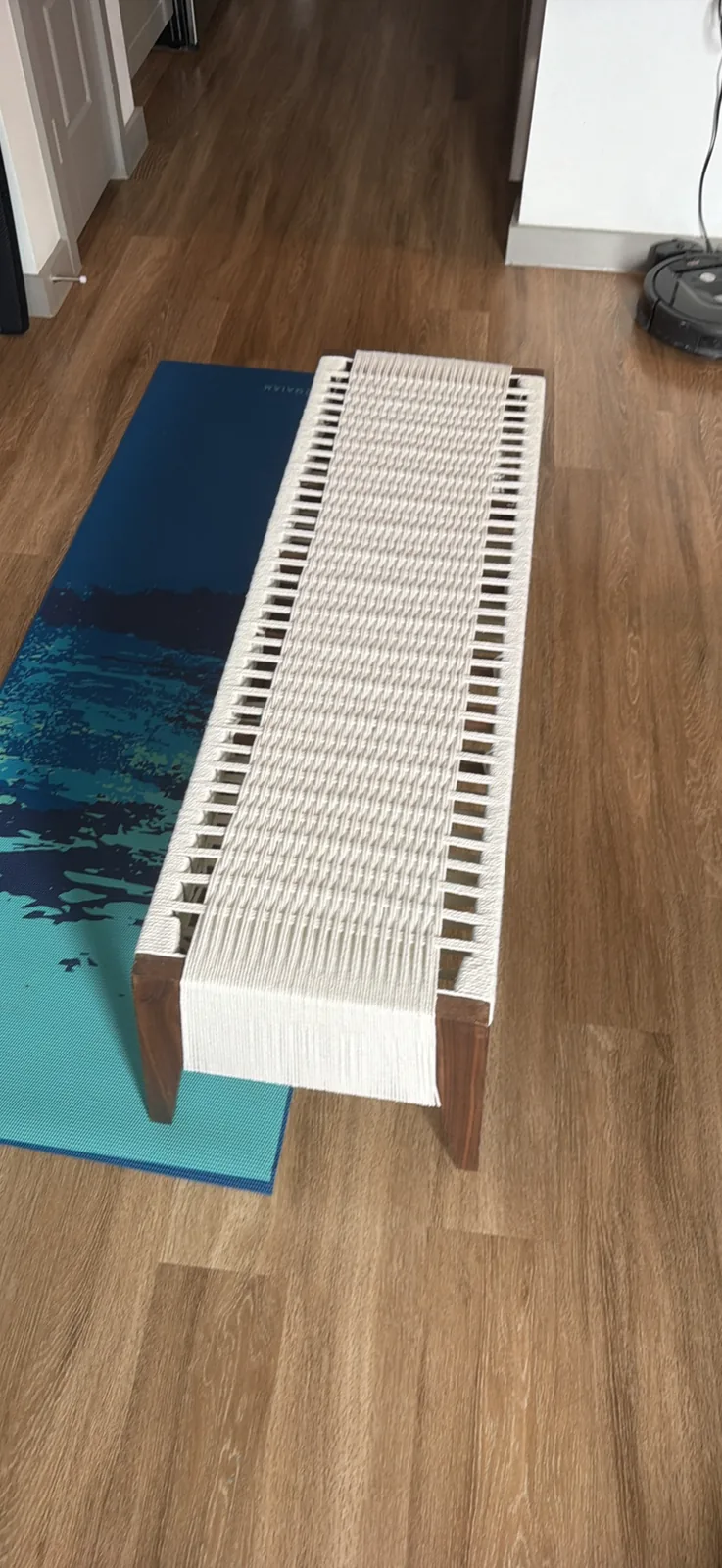 Looking straight down the length of the bench at the finished rope seat, a continuous cream coloured weave running from one end to the other