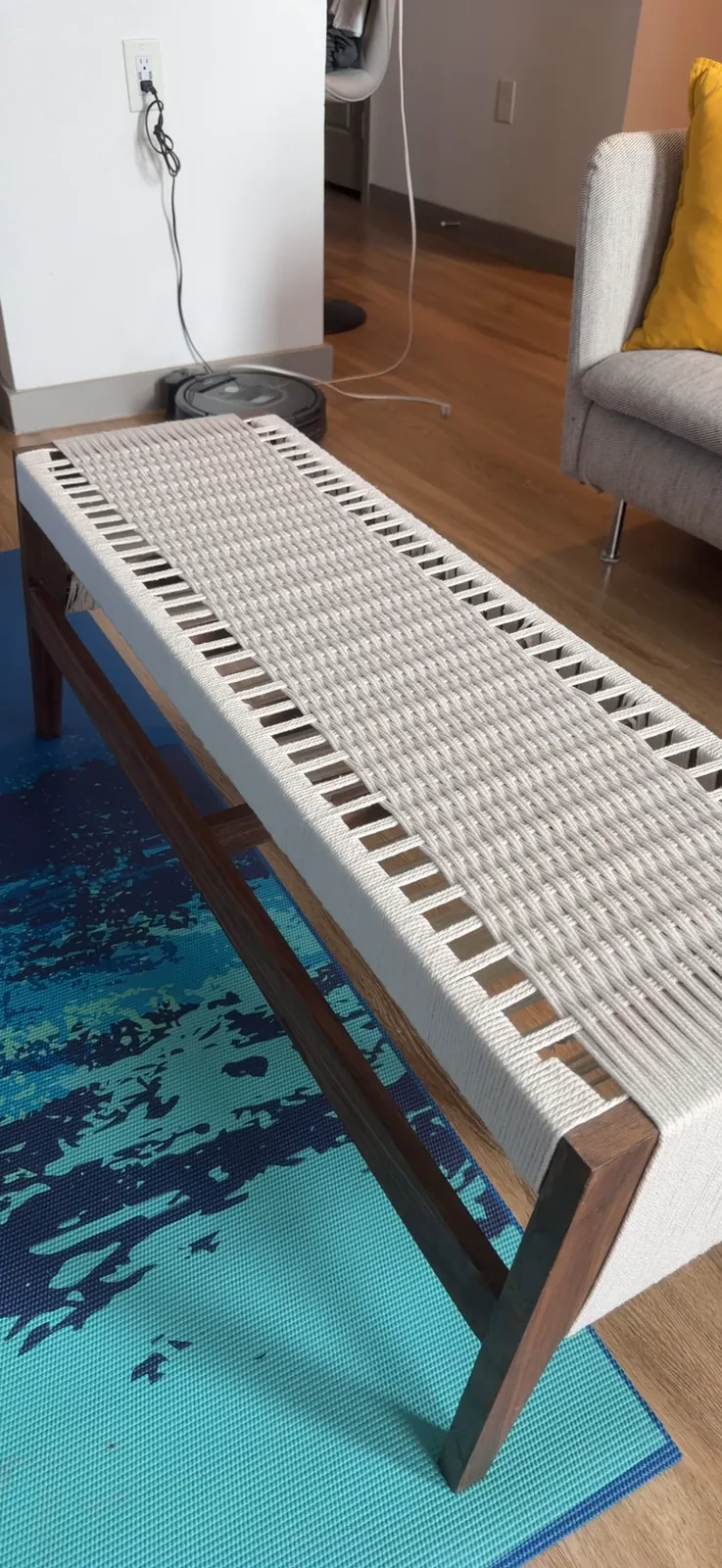 A handheld video walking around the finished bench, moving from a three quarter view down along the length of the woven seat