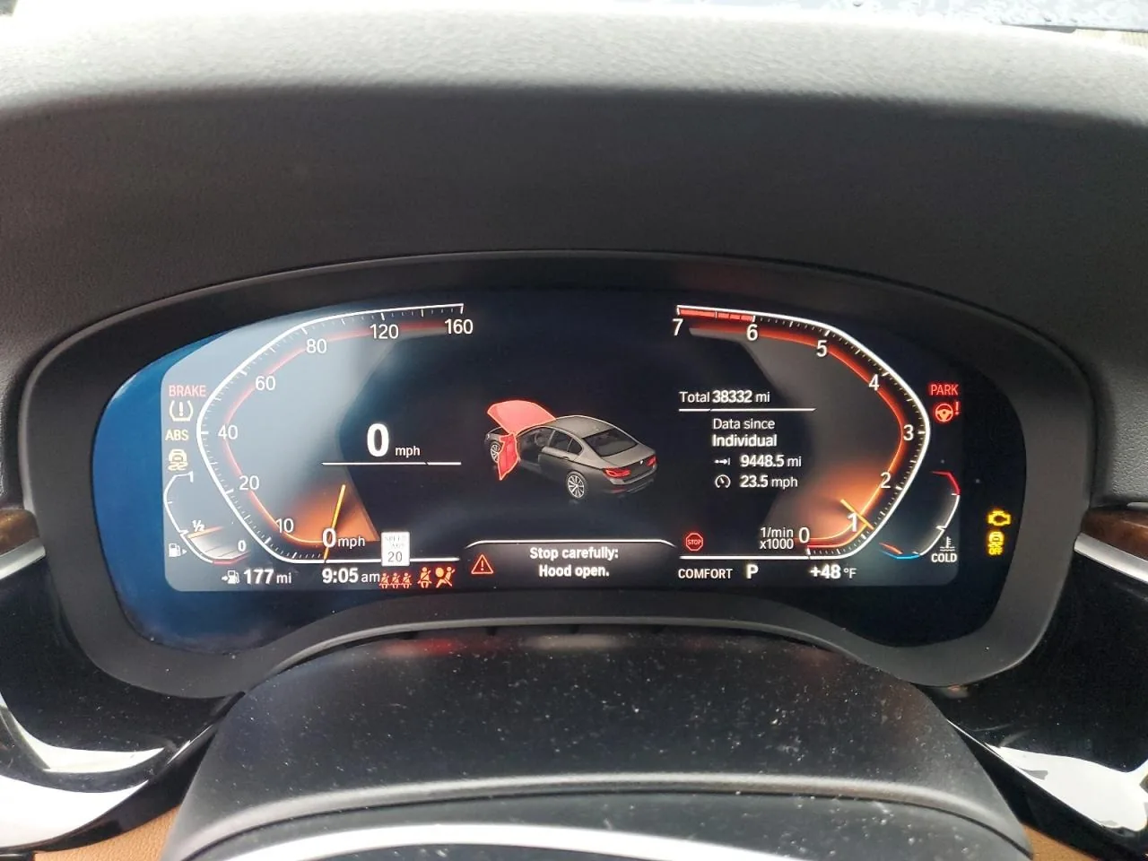 A digital instrument cluster reading 0 mph, with a total of 38,332 miles and a warning that the hood is open