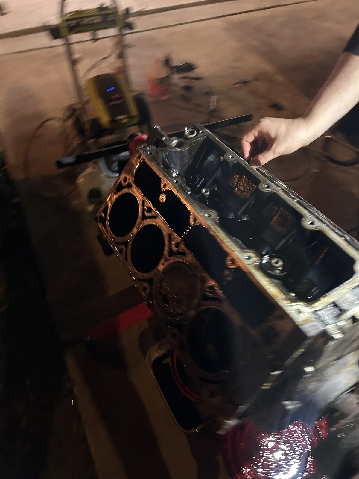 The engine block with the cylinder head removed, looking down onto four open bores and the deck surface
