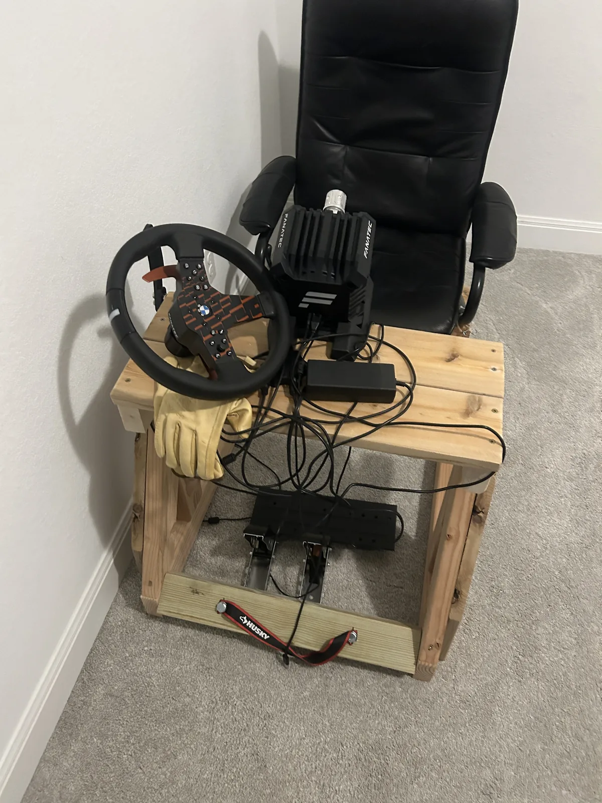 Close view of the rig's wheel deck, a direct drive base bolted to a timber crossmember with a rimmed wheel attached and cabling below