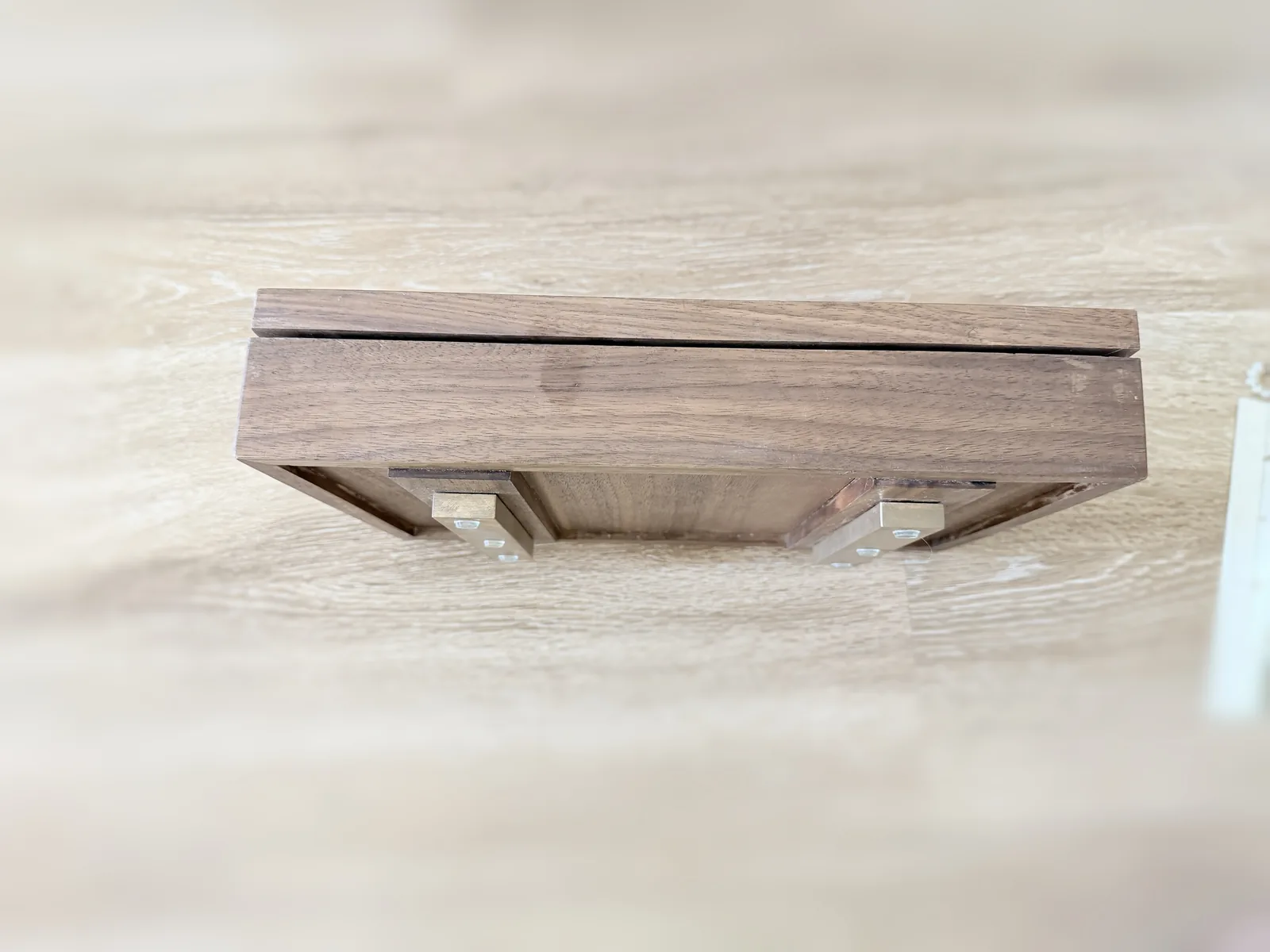 The closed jewelry box seen from above and behind, showing the full length of the back edge and the gap where the lid meets the base