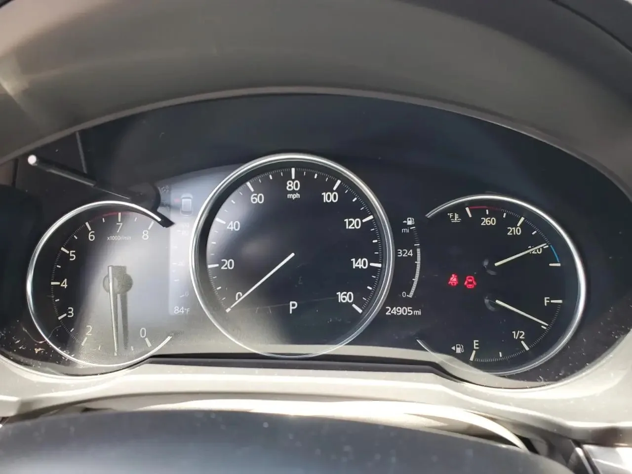 The CX-5's instrument cluster, with the speedometer in the middle and the odometer under it reading 24905 miles