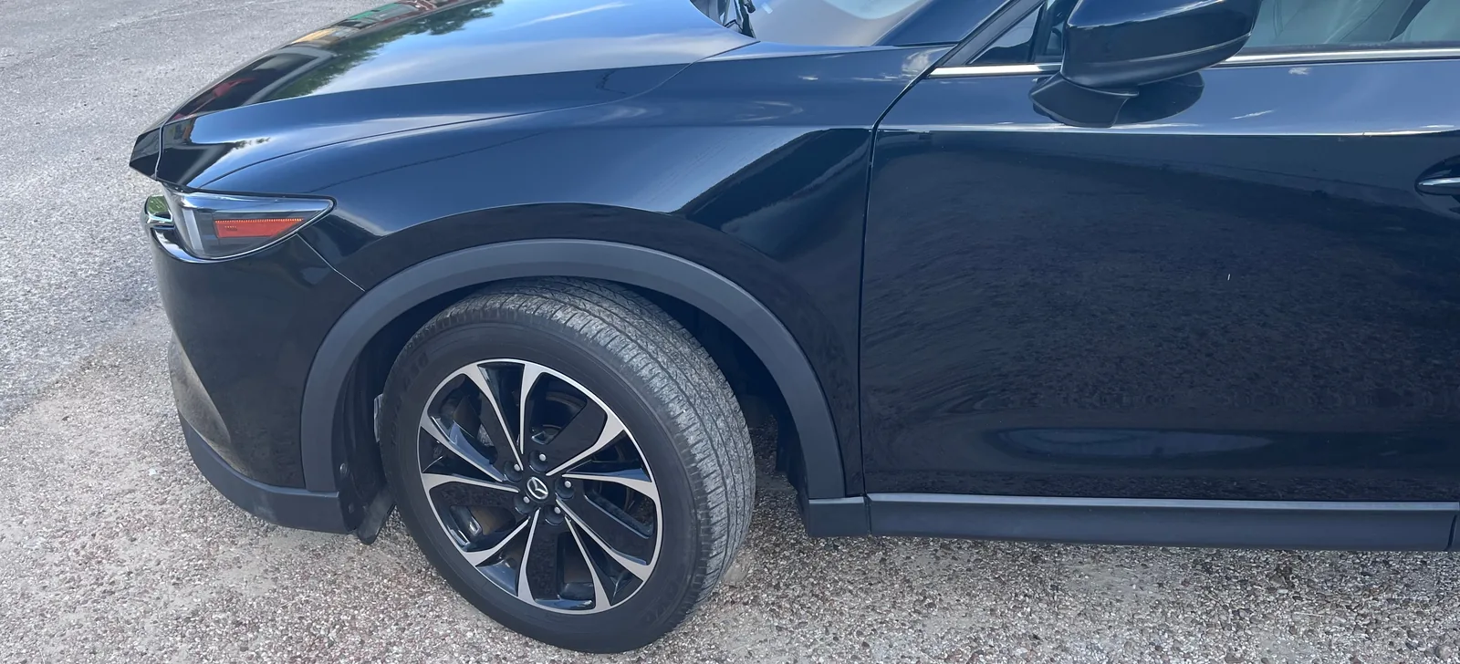 A side view of the CX-5's front left fender, wheel and front door, all glossy black